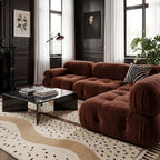 Ivory and tan Beni Ourain rug in modern living room with burgundy sofa and black marble table