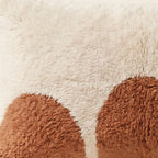 Side view of the Ayyur Moroccan pillow showing its ivory and terracotta wool pile