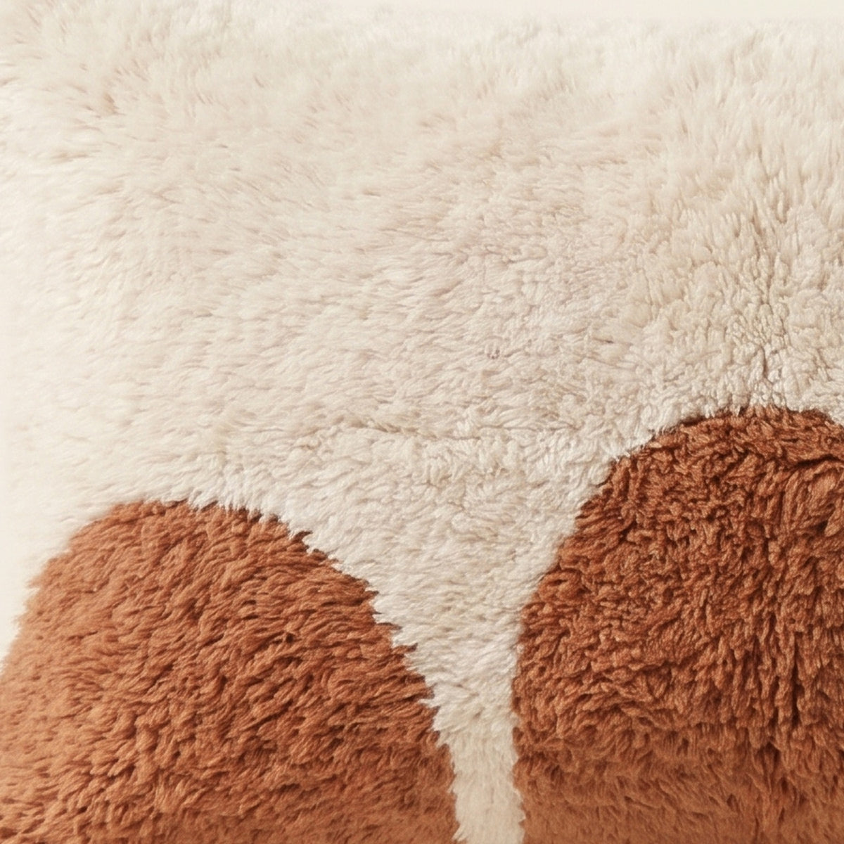 Side view of the Ayyur Moroccan pillow showing its ivory and terracotta wool pile
