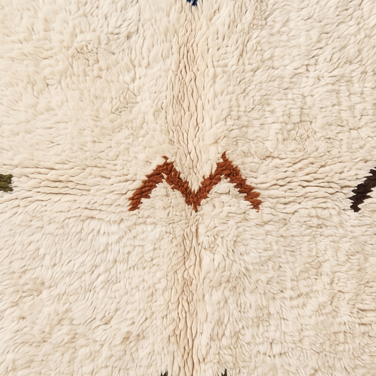 Overhead pile detail showing rust chevron and navy cross motifs in thick handwoven wool