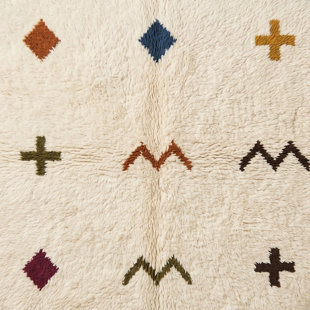 Full-field pile texture close-up displaying scattered terracotta diamond, navy diamond, gold cross, and olive cross against ivory ground