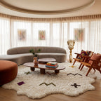 Ivory Beni Ourain scattered symbols rug styled in modern living room with curved sofa and wood furniture