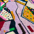Pattern close-up of Tamsa showing angular lilac fields, mustard panels, black outlines and dotted multicolor accents