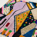 Close-up of the Tamsa Boujaad rug showing plush lilac and mustard hand-knotted wool with black outlines