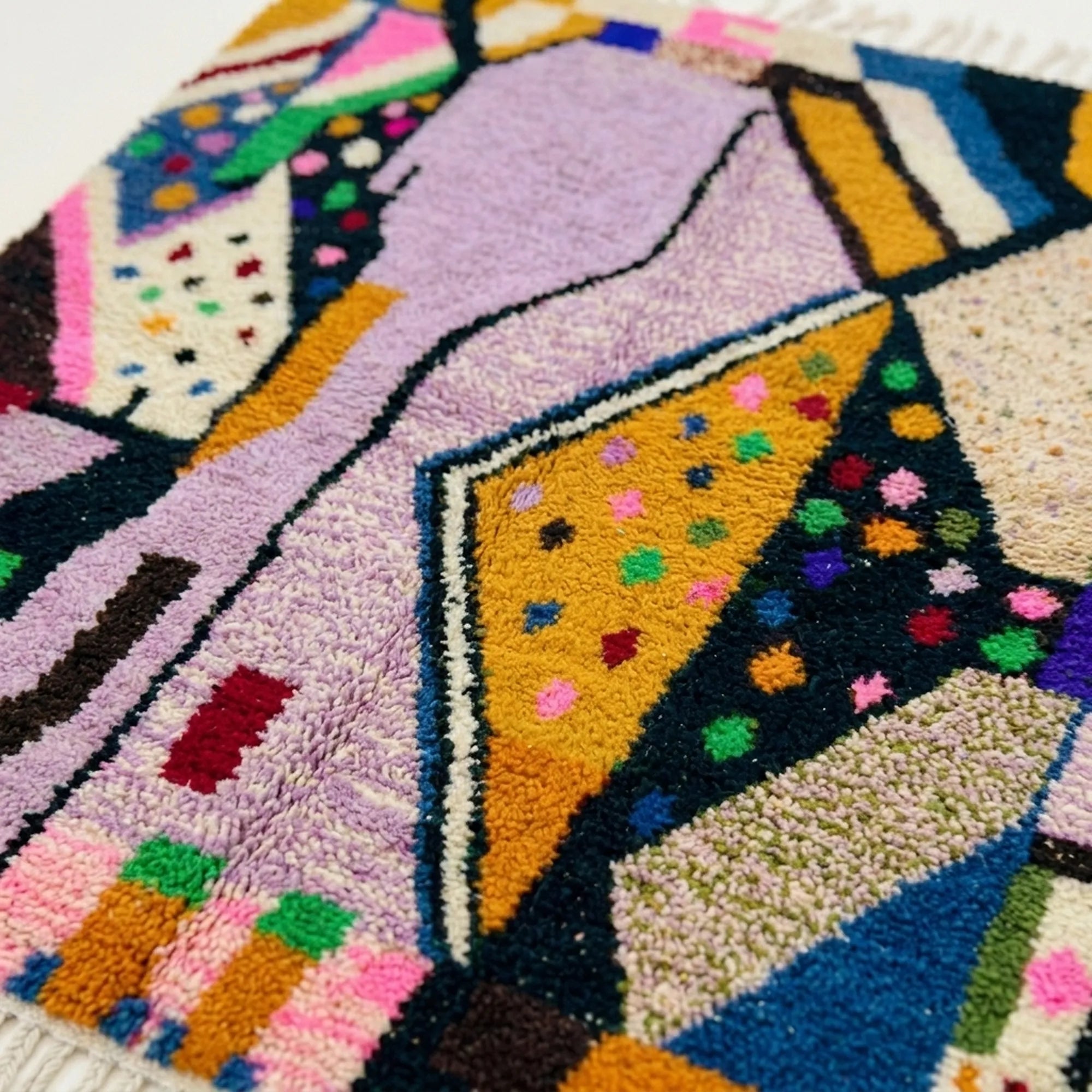 Close-up of the Tamsa Boujaad rug showing plush lilac and mustard hand-knotted wool with black outlines
