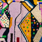 Close-up of Tamsa showing mustard, lilac, green and black angular color blocks with small dotted accents