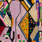 Fringe and edge detail of the Tamsa Boujaad rug beside lilac, mustard and black abstract shapes