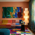 Amzagh Boujaad rug styled in a living room with its magenta, cobalt, mustard and green abstract design visible