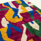 Pattern close-up of Amzagh showing bold magenta, cobalt, mustard and green abstract ribbon forms