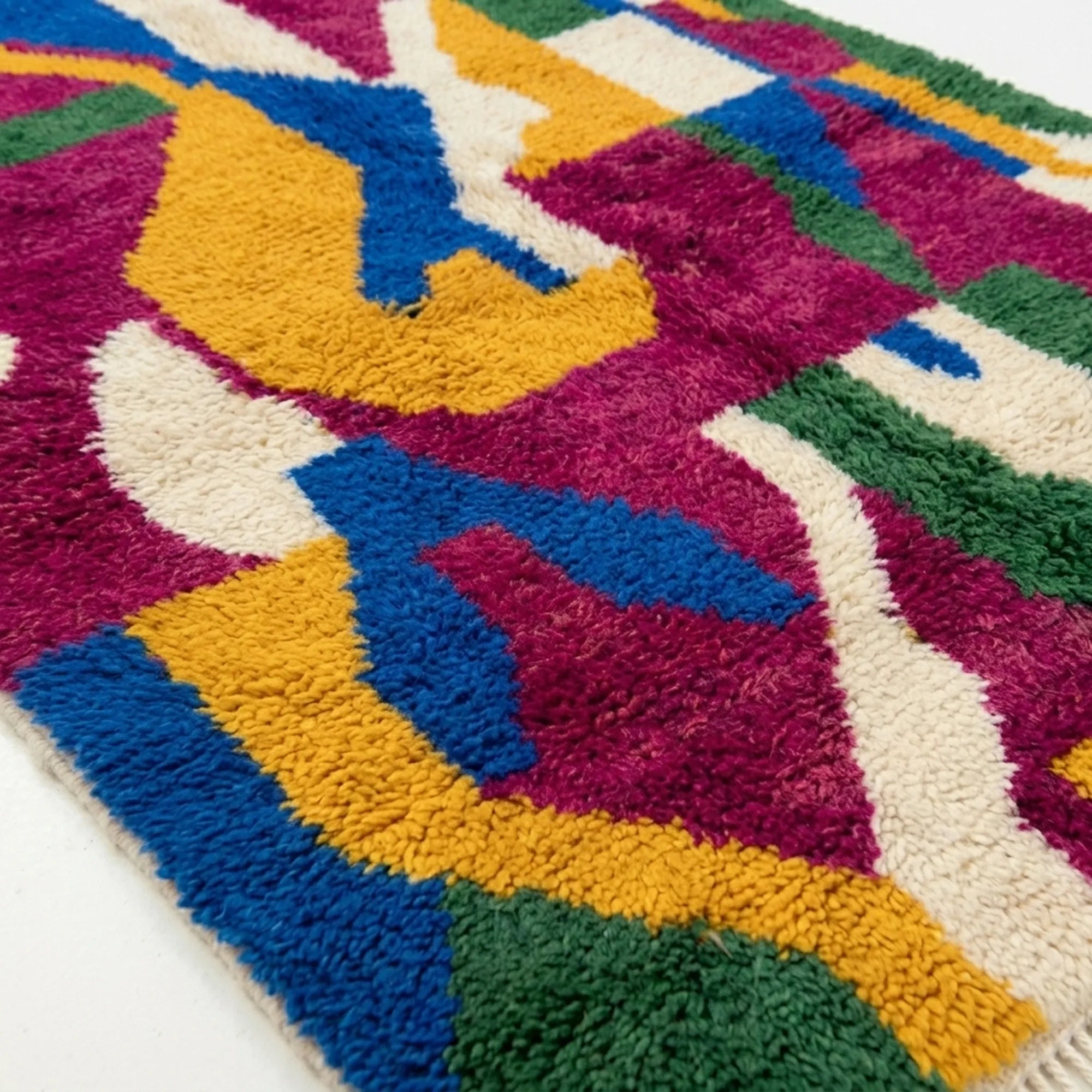 Close-up of the Amzagh Boujaad rug showing plush magenta, cobalt and mustard hand-knotted wool pile