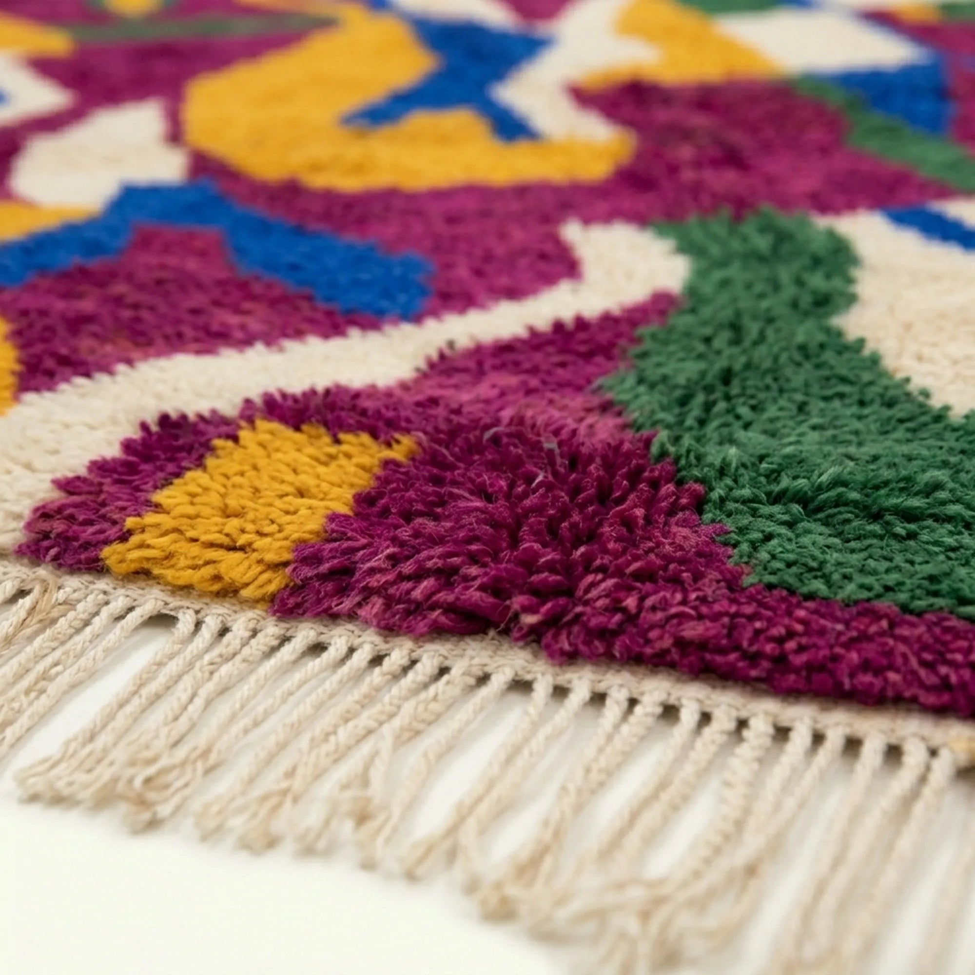 Detail view of Amzagh showing the handwoven transition between magenta, mustard, cobalt and green motifs