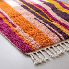 Angled detail of Tanina rug showing plush hand-knotted wool pile and cream fringe
