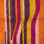 Close-up of hand-knotted vertical stripes showing yellow, magenta and purple wool tones