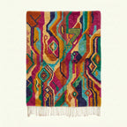 Full rug view of Awrmas showing magenta, orange, teal, green and cream flowing diamond motifs