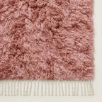 Detail of mauve Beni Ourain rug corner with ivory fringe and pile edge