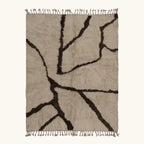 Full view of the Aylal mushroom and dark brown Beni Ourain rug with a branch line design.