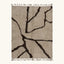 Full view of the Aylal mushroom and dark brown Beni Ourain rug with a branch line design.