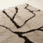 Angled view of the Aylal mushroom and dark brown Beni Ourain rug showing the branch line design.