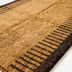 Close-up texture detail of mustard and chocolate Mrirt rug showing dense knotted pile and stripe pattern