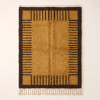 Mustard and chocolate Mrirt rug with linear stripe column border design and solid centre, flat lay on neutral background