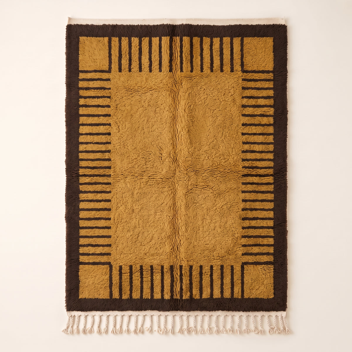 Mustard and chocolate Mrirt rug with linear stripe column border design and solid centre, flat lay on neutral background