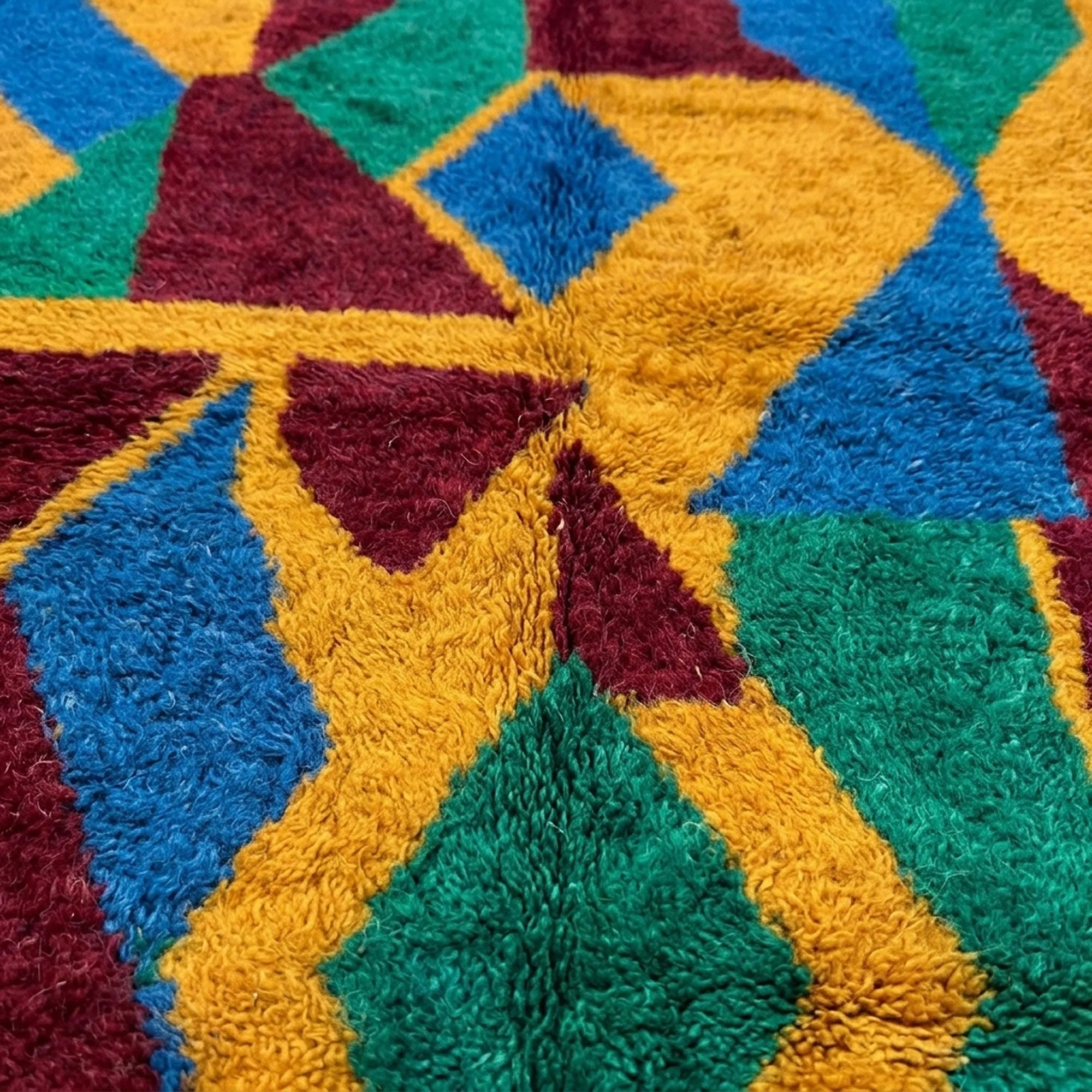 Pattern close-up of Imazigh showing mustard, green, cobalt and burgundy interlocking triangles and diamonds