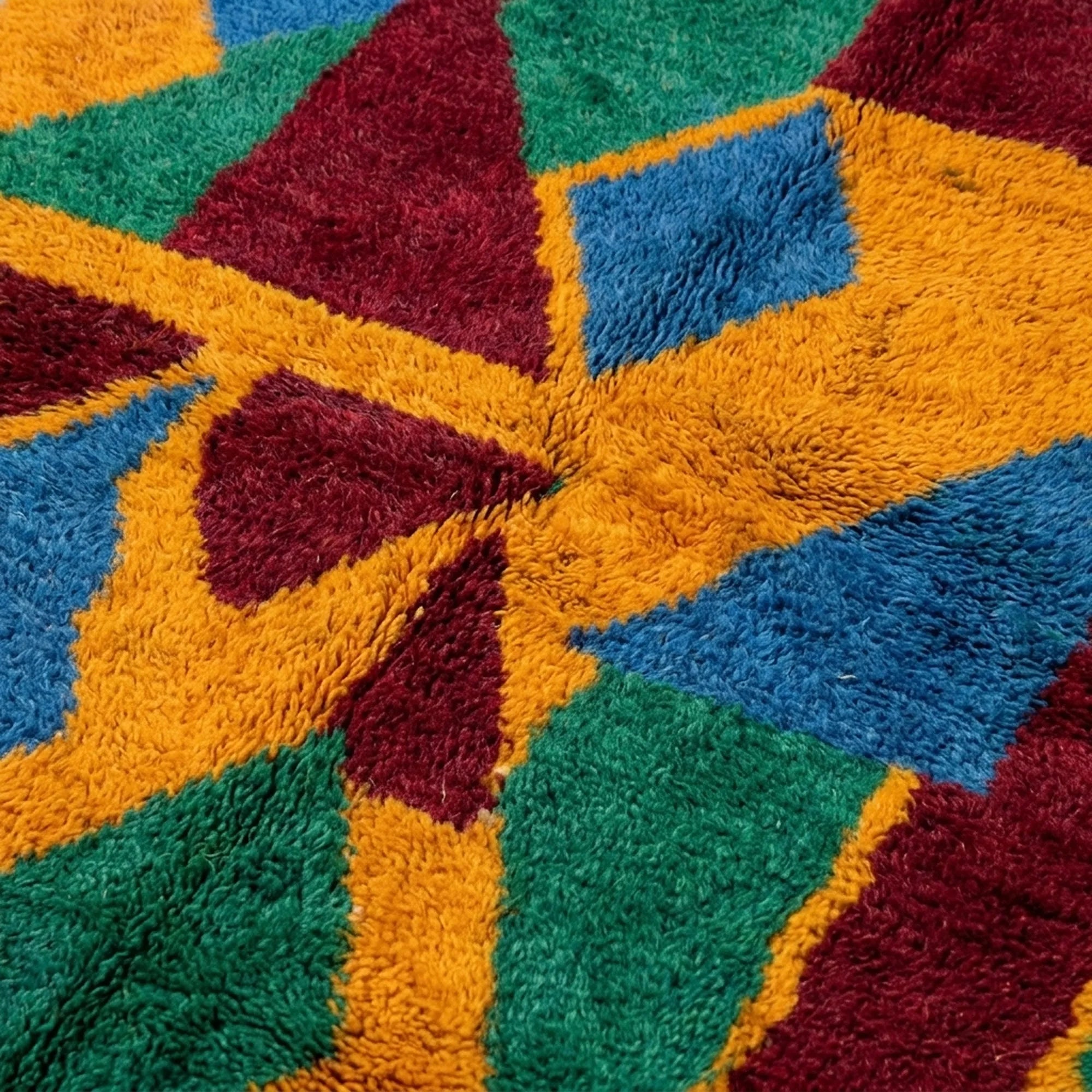 Fringe and edge detail of the Imazigh Boujaad rug beside bold green, mustard and burgundy geometric shapes