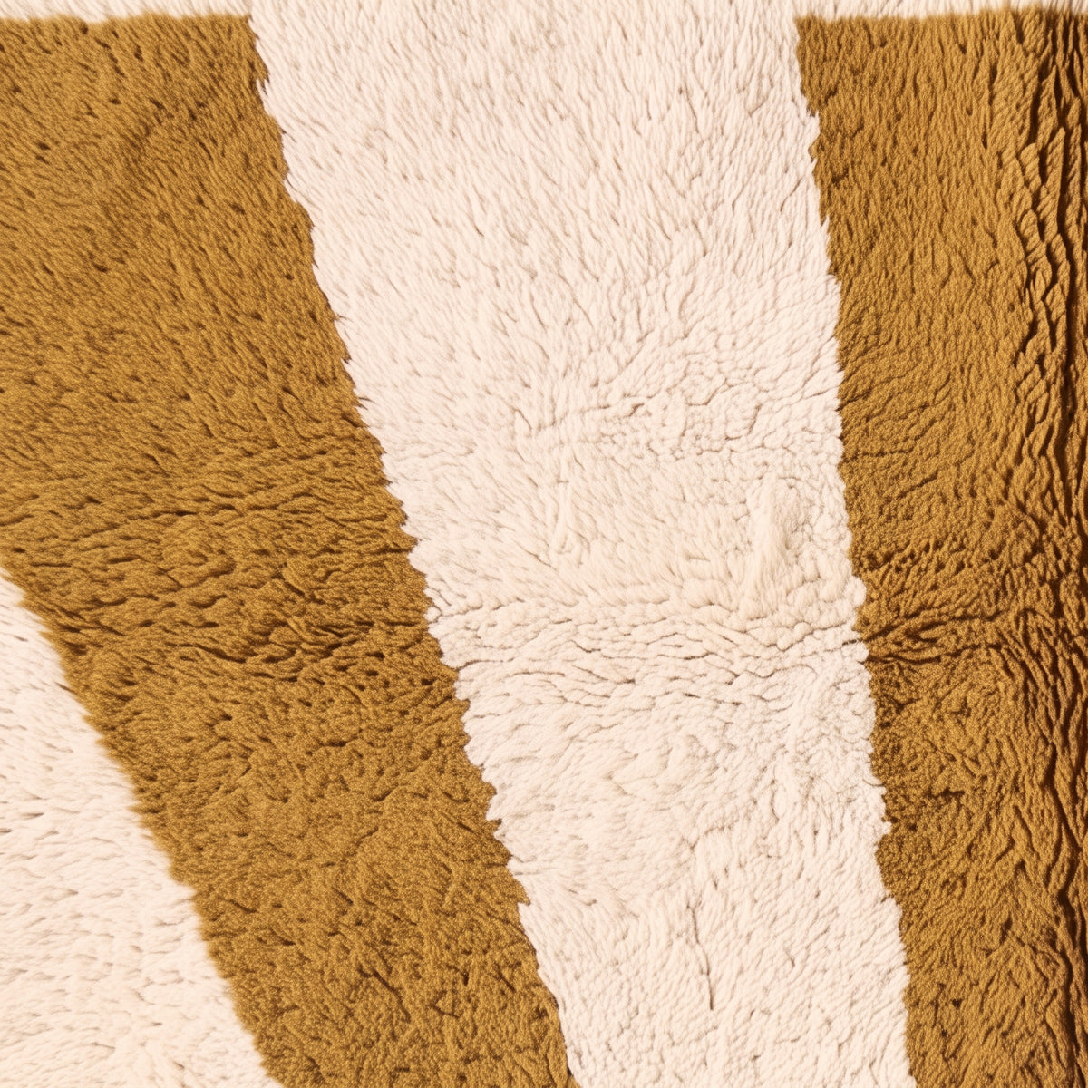 Textured close-up of mustard and ivory color blocking showing depth and pile contrast between dyed wool sections