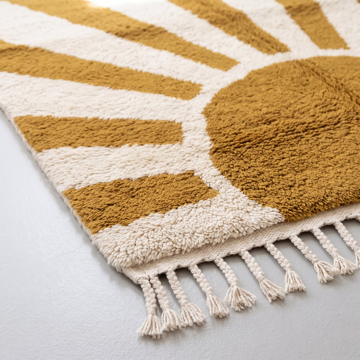 Detailed view of mustard rays and ivory stripes showing dense wool knot construction and fringe edge