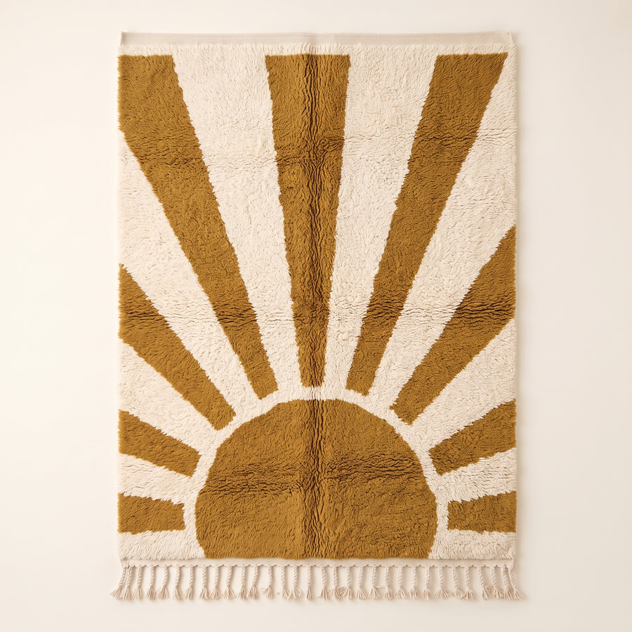 Mustard and ivory Beni Ourain rug with geometric sunburst design radiating from central semicircle, flat lay on plain background