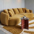 Mustard and ivory Beni Ourain sunburst rug styled in living room under curved mustard sofa with glass side table