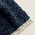 Close-up of navy wool pile texture and ivory fringe on Tamazirt rug