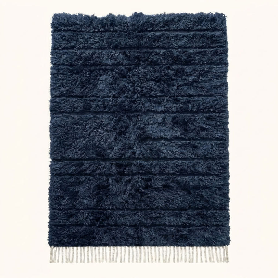 Navy Beni Ourain rug with textured horizontal bands, ivory fringe, flat view on plain background