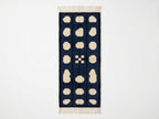 Navy and cream Mrirt runner with three columns of rounded pebbles and central geometric cross motif, flat view on plain background