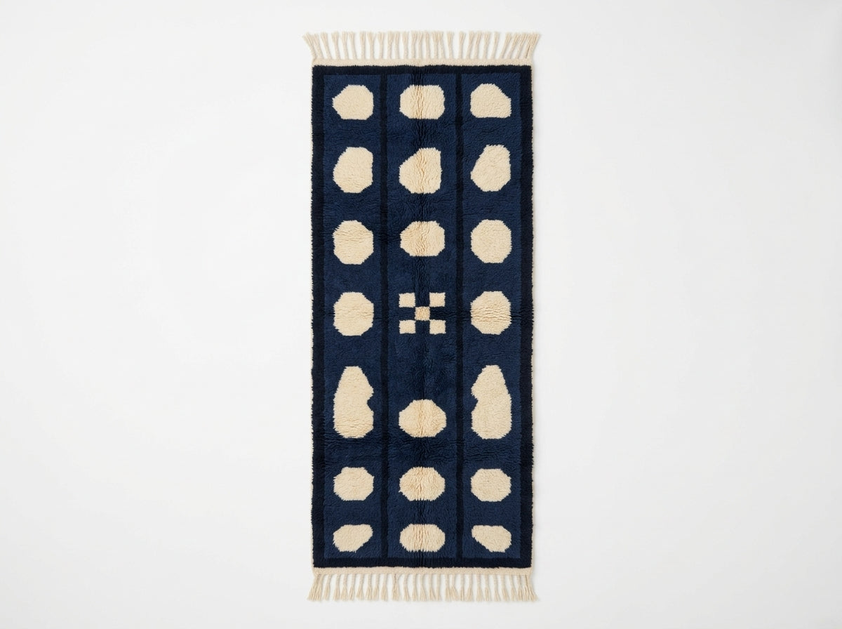 Navy and cream Mrirt runner with three columns of rounded pebbles and central geometric cross motif, flat view on plain background