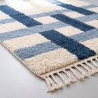 Corner detail of navy and ivory Beni Ourain rug showing fringe and thick pile construction