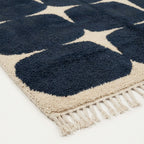 Angled view of the Tamazirt navy and ivory hand-knotted Beni Ourain rug.