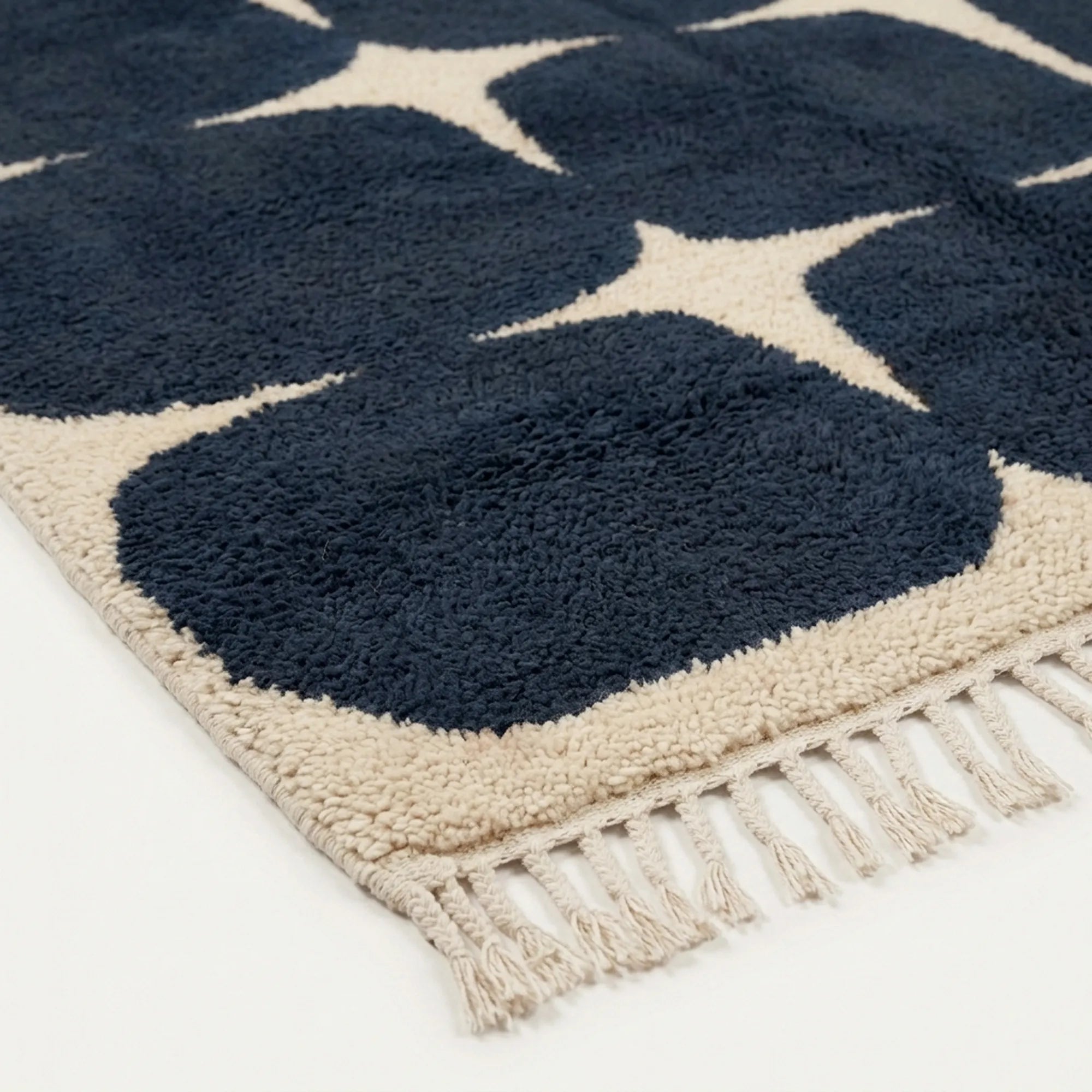 Angled view of the Tamazirt navy and ivory hand-knotted Beni Ourain rug.