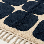 Border detail of the Tamazirt navy and ivory rounded grid rug.