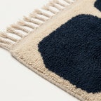 Close-up of the natural Atlas wool texture on the Tamazirt navy and ivory rug.