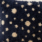 Side view of the Adfel Moroccan pillow showing its navy and ivory wool pile