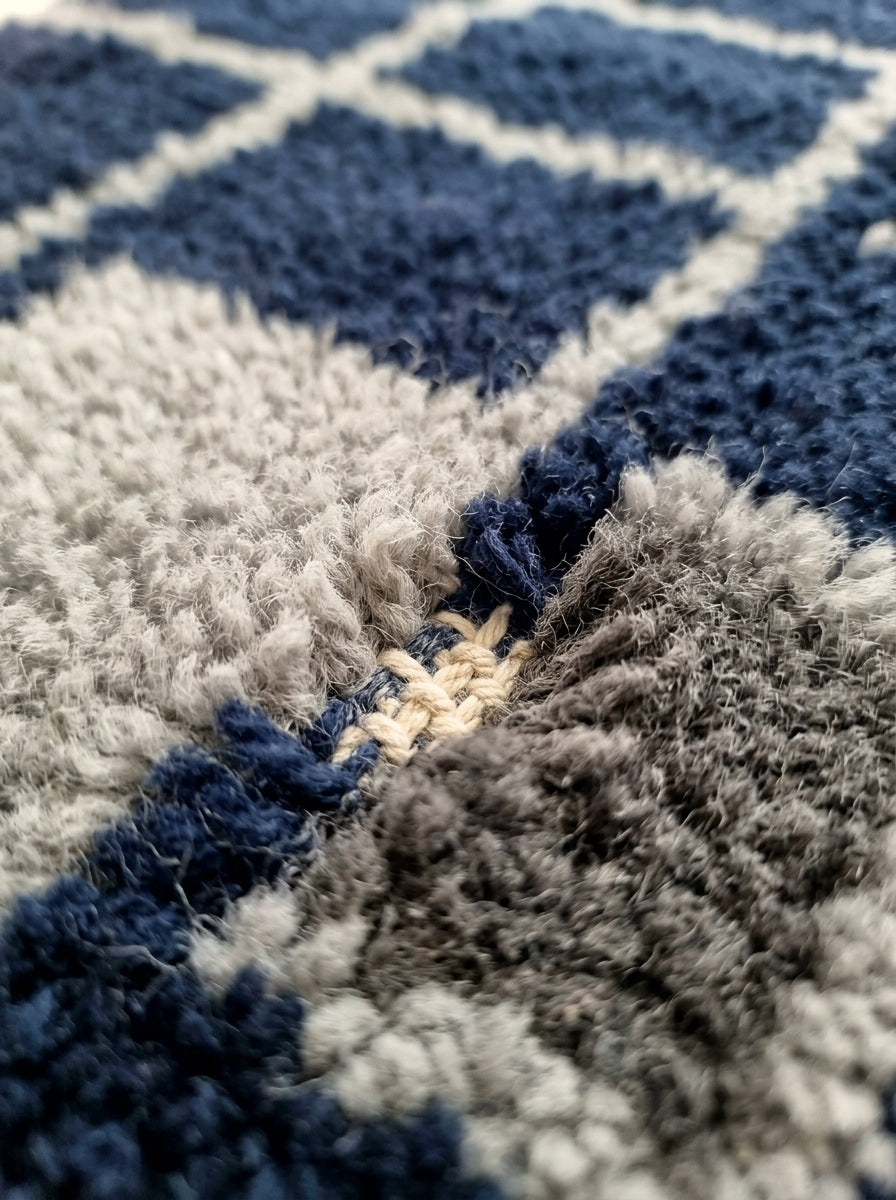 Close-up texture of navy, ivory and grey wool pile showing dense hand-knotted construction