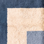 Angled view of color blocks showing navy base, cream rectangle, slate blue rectangle and textured plush pile