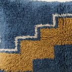 Side view of the Adrar Moroccan pillow showing its navy and mustard wool pile