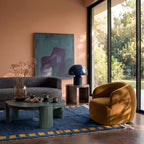 Navy and saffron Mrirt rug in modern living room with ochre chair and green side table