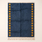 Navy Mrirt rug with saffron-yellow square columns on both sides, flat lay on cream background