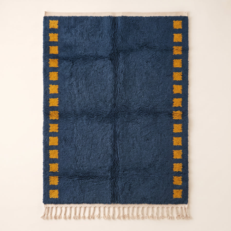 Navy Mrirt rug with saffron-yellow square columns on both sides, flat lay on cream background
