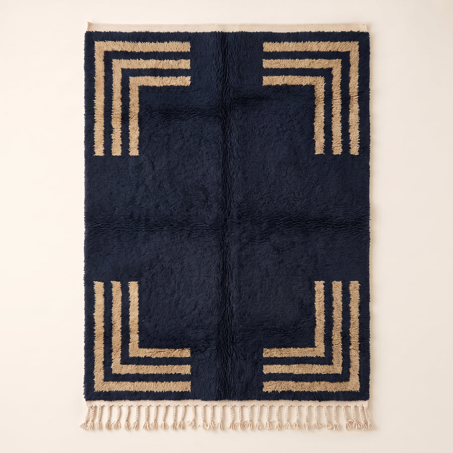 Navy Beni Ourain rug with tan concentric rectangular corner frames, full flat view