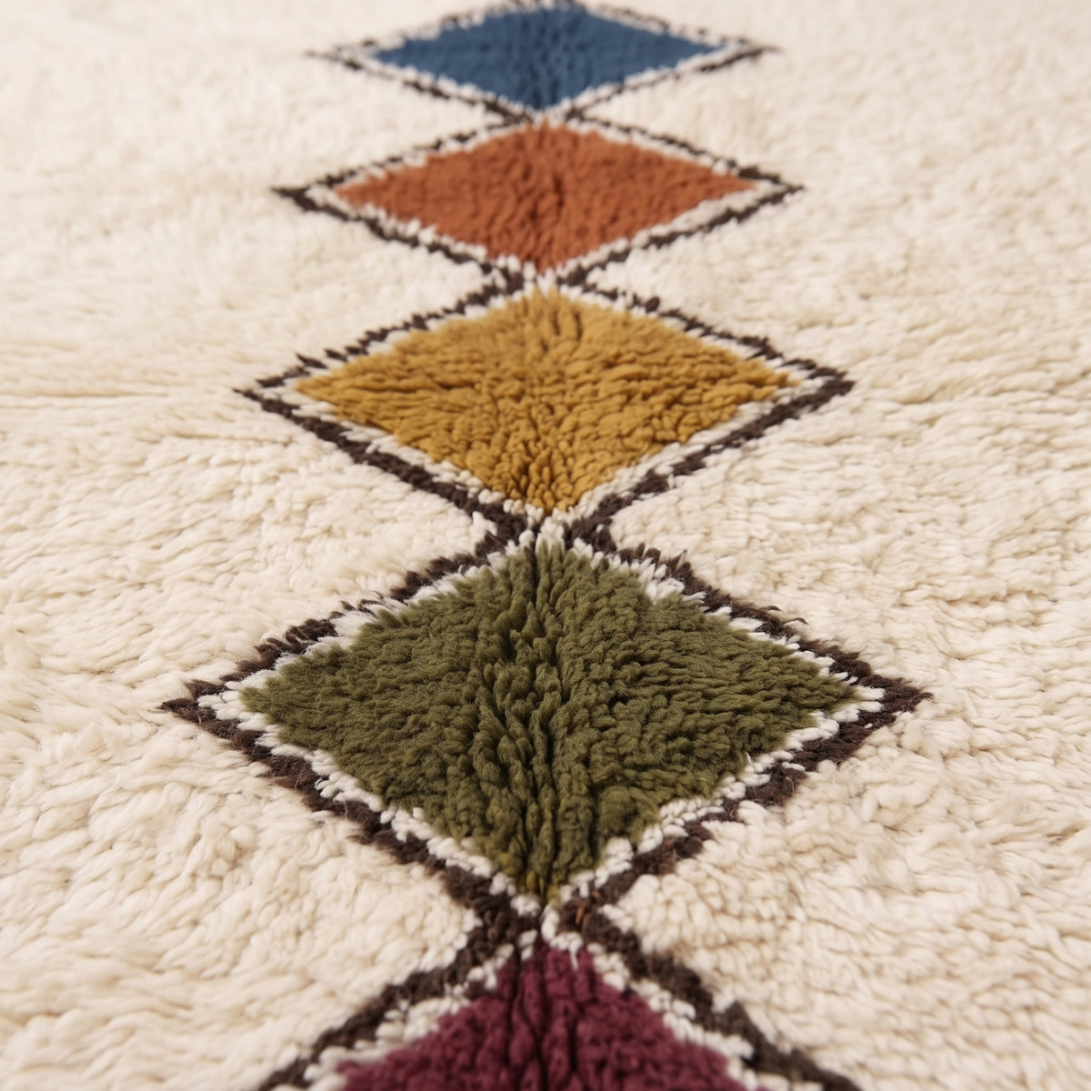 Close-up of Tafrara pile texture showing thick soft wool and detailed diamond lozenge outlines in dark brown and cream