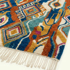 Fringe and lower-edge detail of the Azwawen Boujaad rug with teal, terracotta and cream motifs